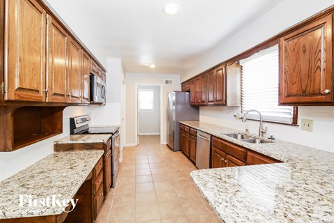 A kitchen with wooden cabinets and granite countertops.