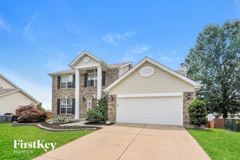 a home with a white garage door and a brick house