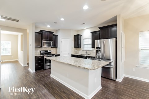 a kitchen with black cabinets and a granite counter top