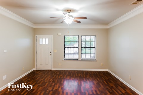 A room with a wooden floor and a ceiling fan.