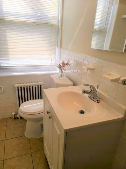 A white toilet sits next to a sink in a bathroom.