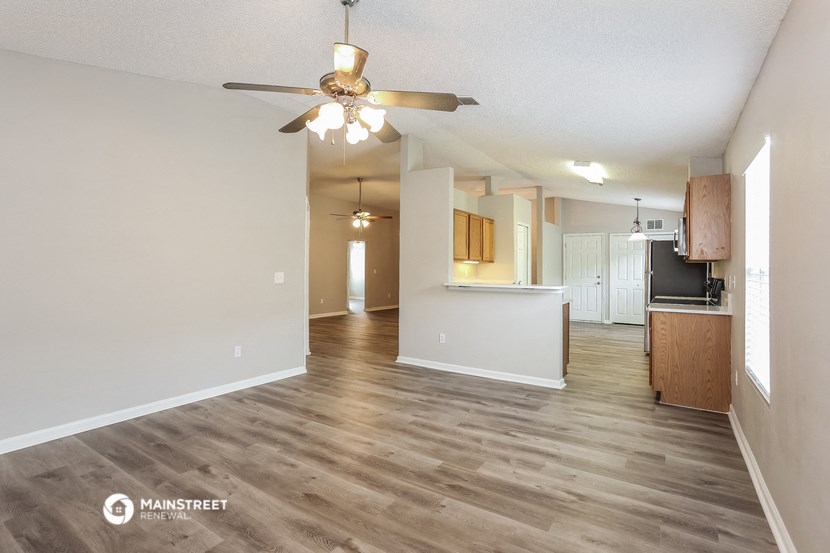 an open living room and kitchen with a ceiling fan