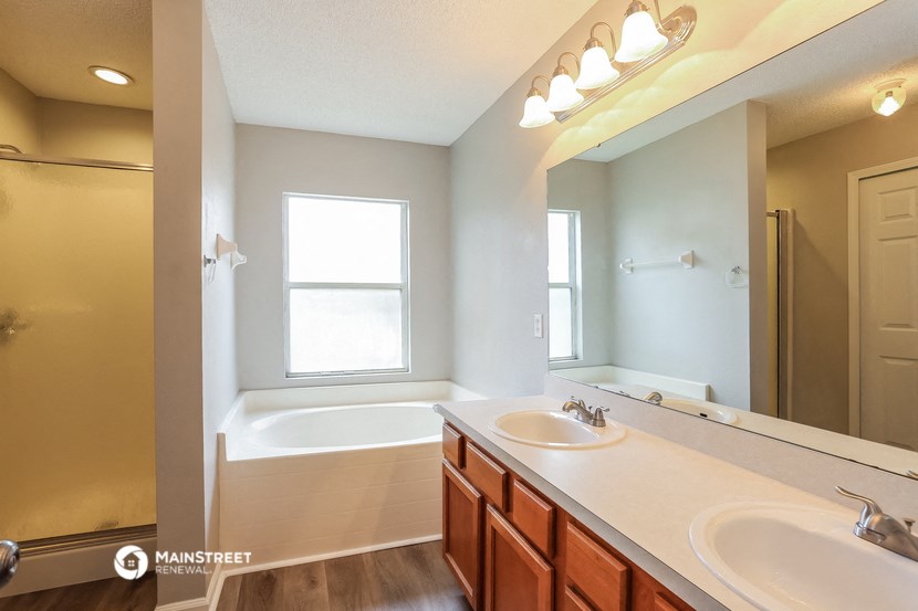 the master bathroom has dual sinks and a large mirror