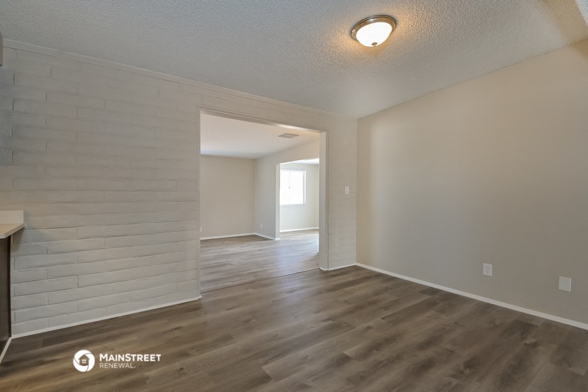 the spacious living room and dining room of an apartment