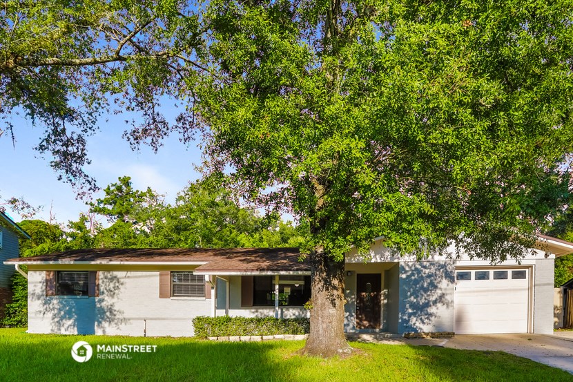 a white house with a large tree in front of it