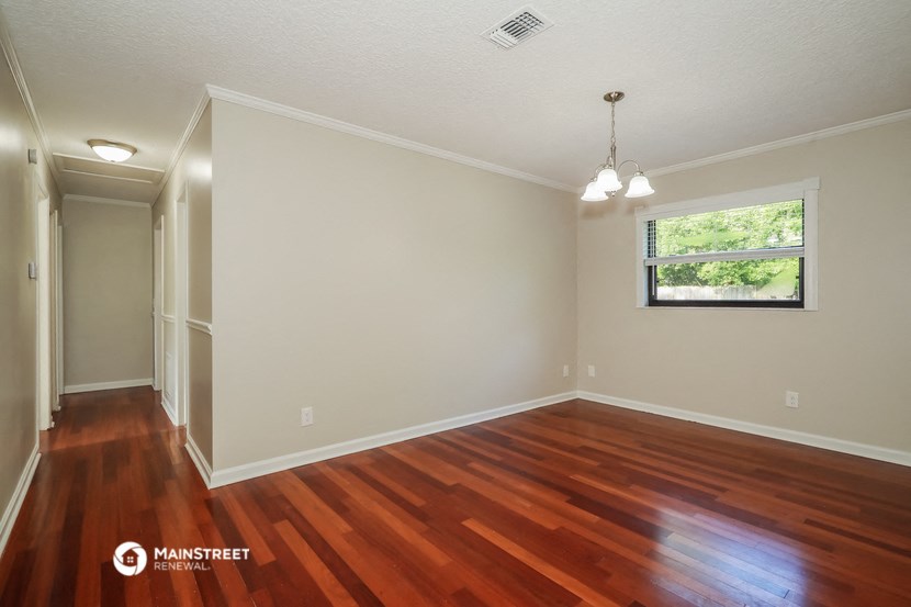 an empty living room with wood floors and a window