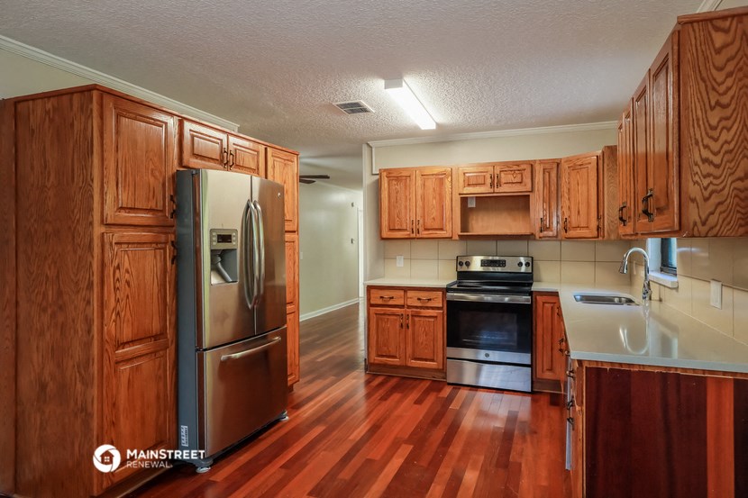 a kitchen with wooden cabinets and stainless steel appliances
