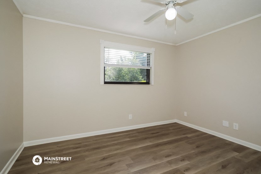 a bedroom with a window and a ceiling fan