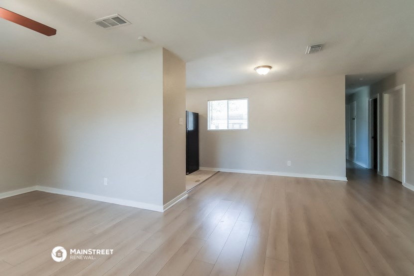 an empty living room with white walls and wood floors