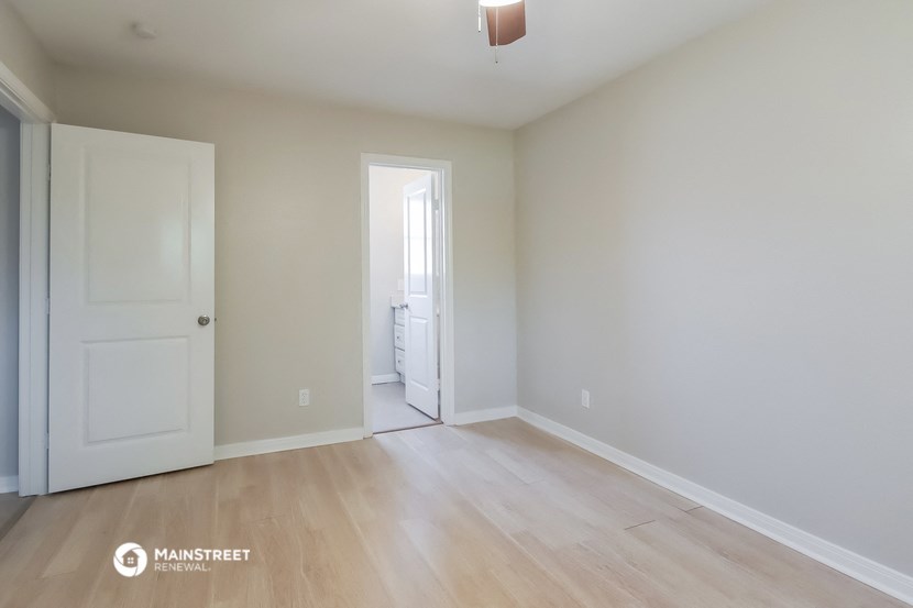 an empty room with white walls and a wooden floor