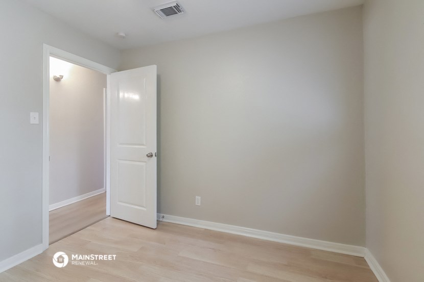 a room with a white door and a wooden floor