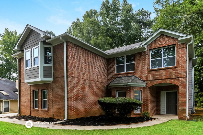 a brick house with a front yard and a driveway