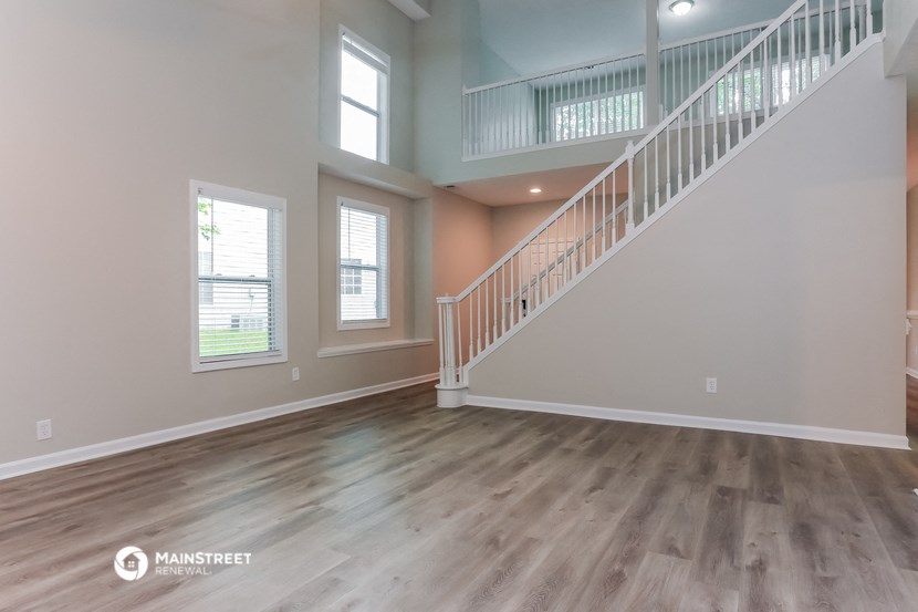 the spacious living room with stairs to the second floor