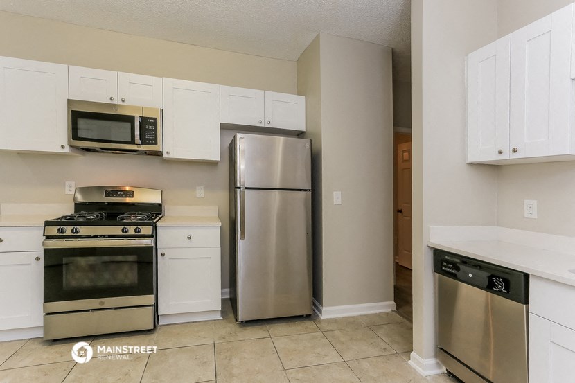 a kitchen with stainless steel appliances and white cabinets