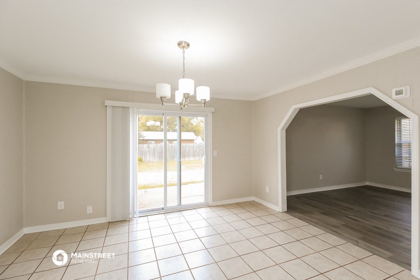 an empty living room with a sliding glass door to a yard