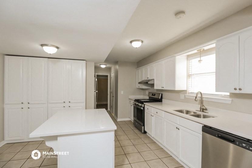 a large kitchen with white cabinets and a sink