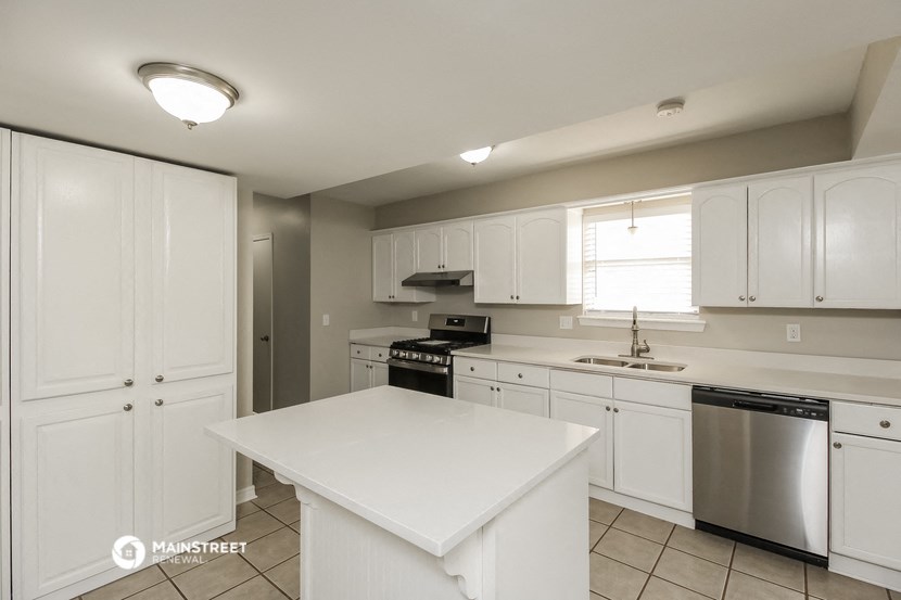 a kitchen with white cabinets and a white counter top