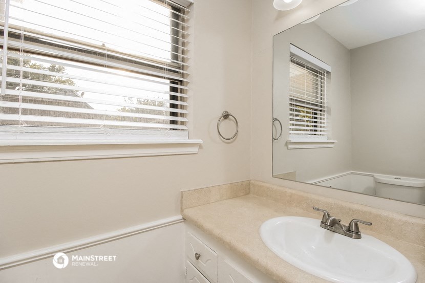 a bathroom with a sink and a mirror and a window