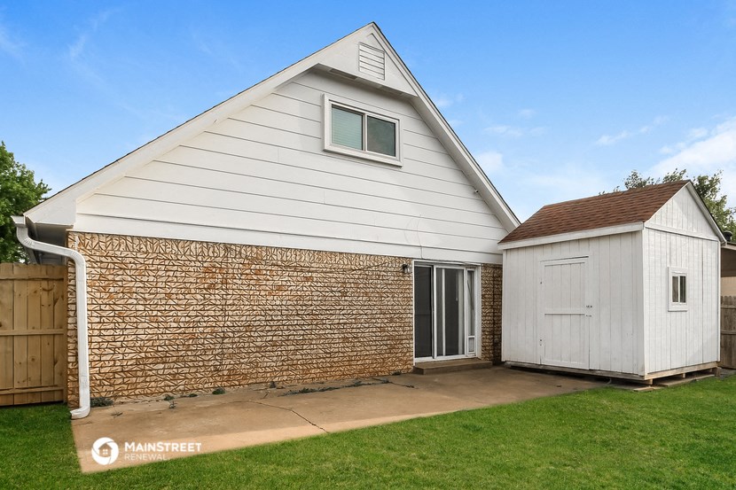 a white house with a garage and a shed on the side