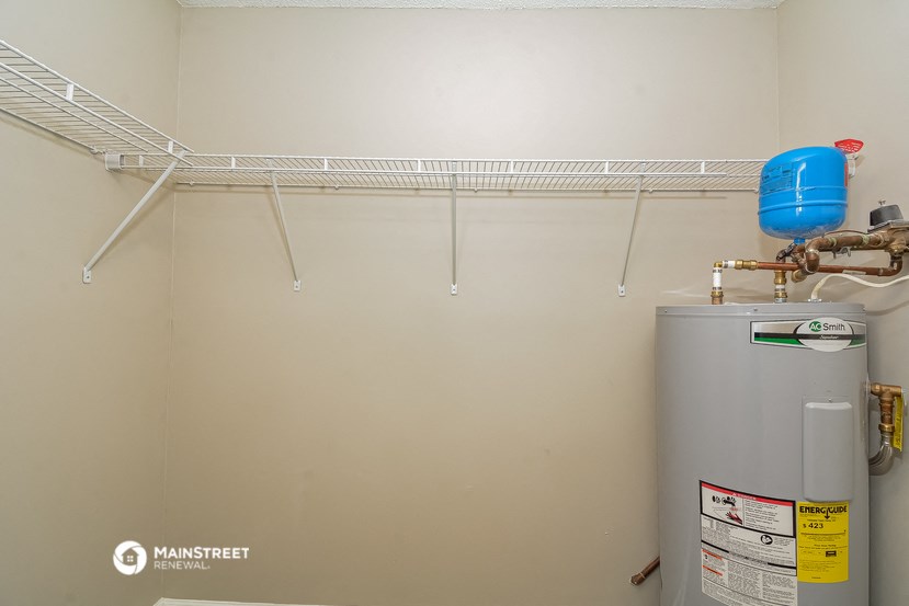 a bathroom with a water heater and a rack on the wall