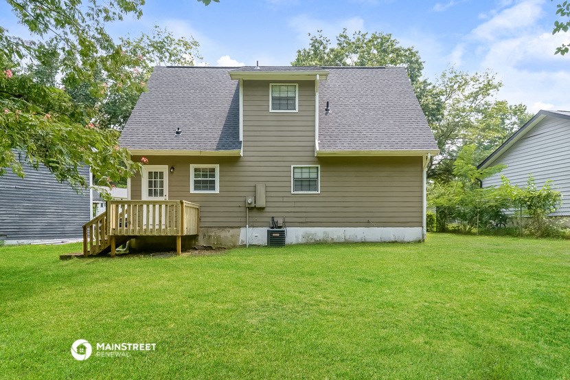 the back of a house with a yard and a deck