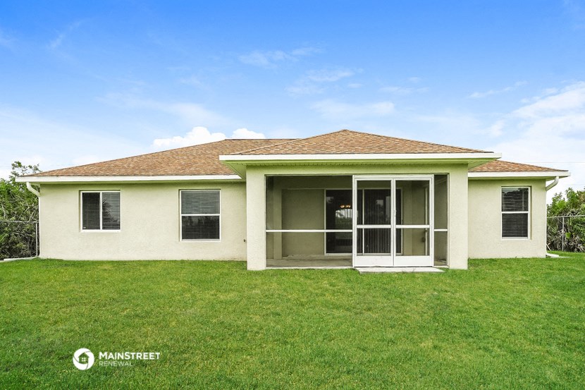 a small white house with a lawn and a door