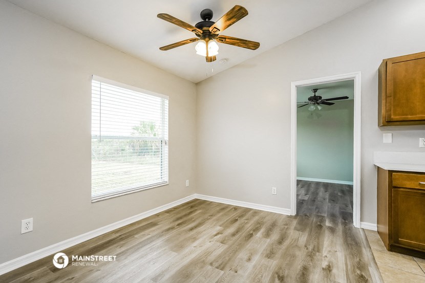 an empty room with a ceiling fan and a window