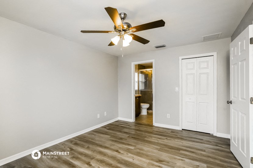 the living room of an apartment with a ceiling fan