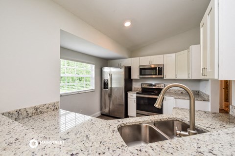 a kitchen with granite counter tops and stainless steel appliances