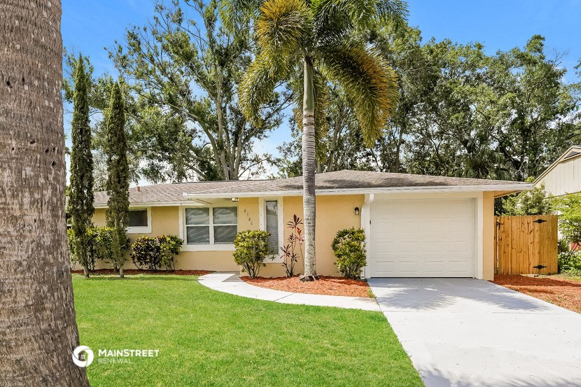 a yellow house with a palm tree in front of it