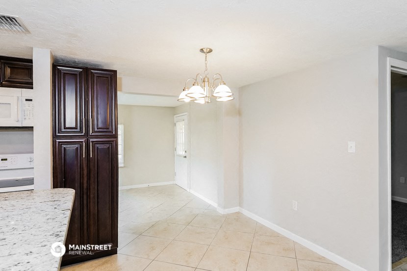 an empty kitchen and dining room with a chandelier