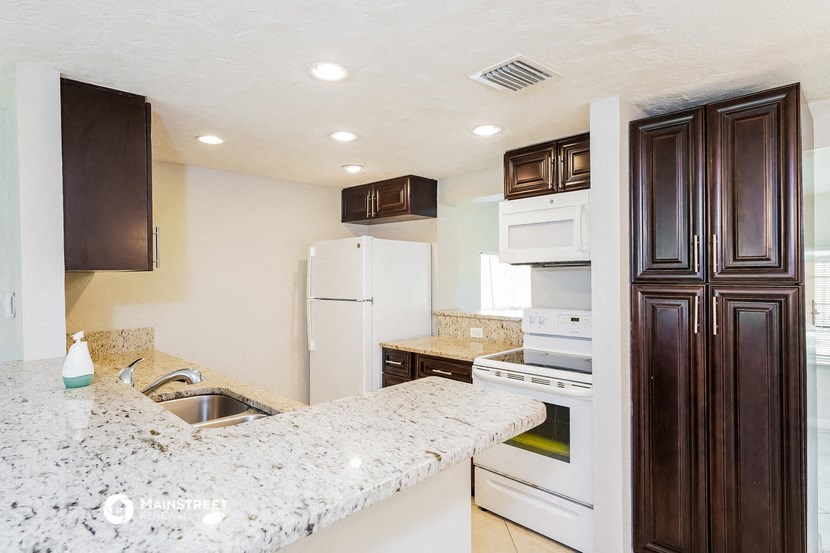 a kitchen with white appliances and a granite counter top