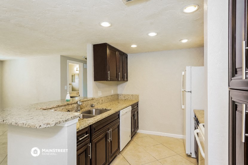 a kitchen with a sink and a refrigerator and a counter top