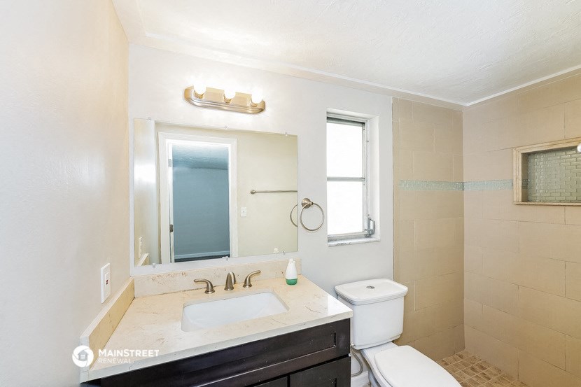 a bathroom with a sink toilet and a mirror