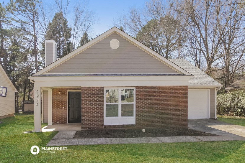 the front of a brick house with a white door