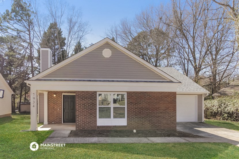 the front view of a brick house with a white door