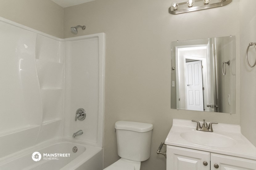 a white bathroom with a shower toilet and sink