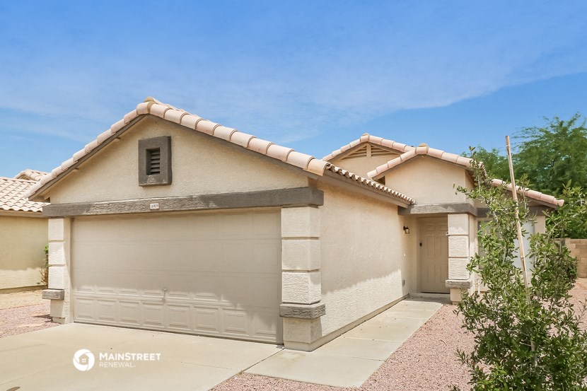 a white house with a garage door and a tile roof