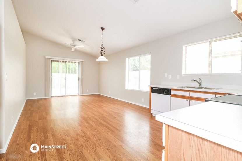 an empty kitchen and living room with wood floors and white walls