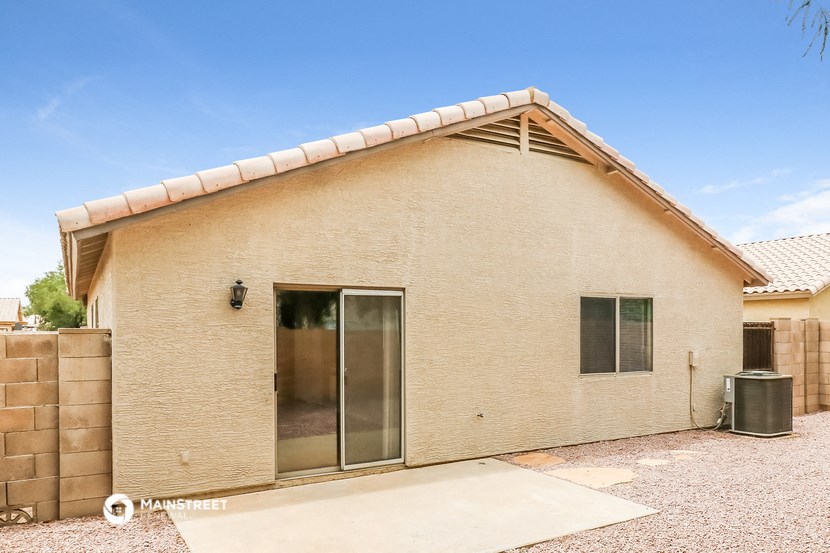 a small tan brick house with a large glass door