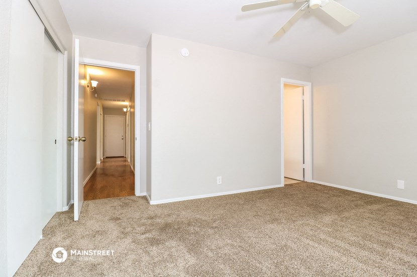 a bedroom with a carpeted floor and a ceiling fan