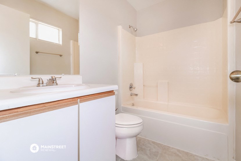 a bathroom with a toilet and a sink and a bath tub