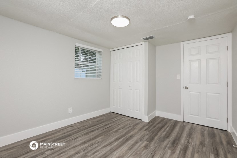 the interior of an empty room with white walls and wood flooring