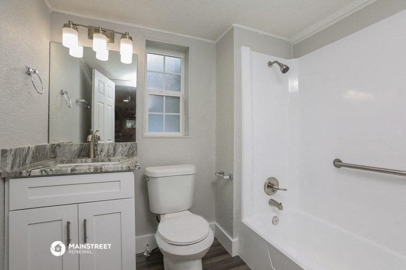 a bathroom with a toilet and a tub and a sink