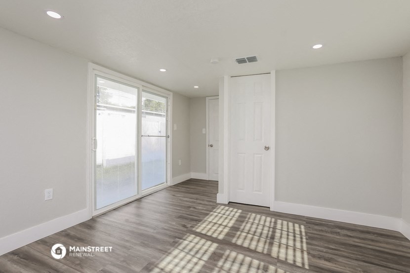 the living room of a new home with white walls and wood floors