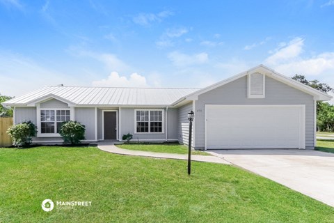 a white house with a lawn and a driveway