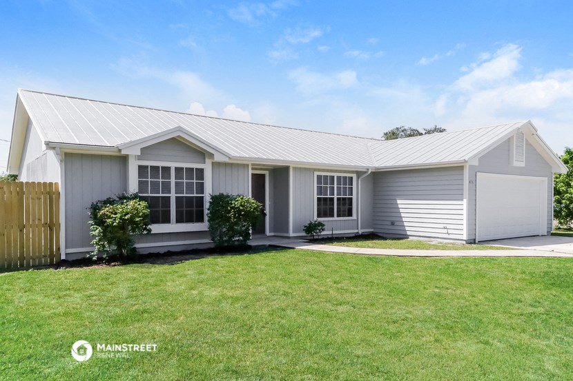 a small white house with a lawn in front of it