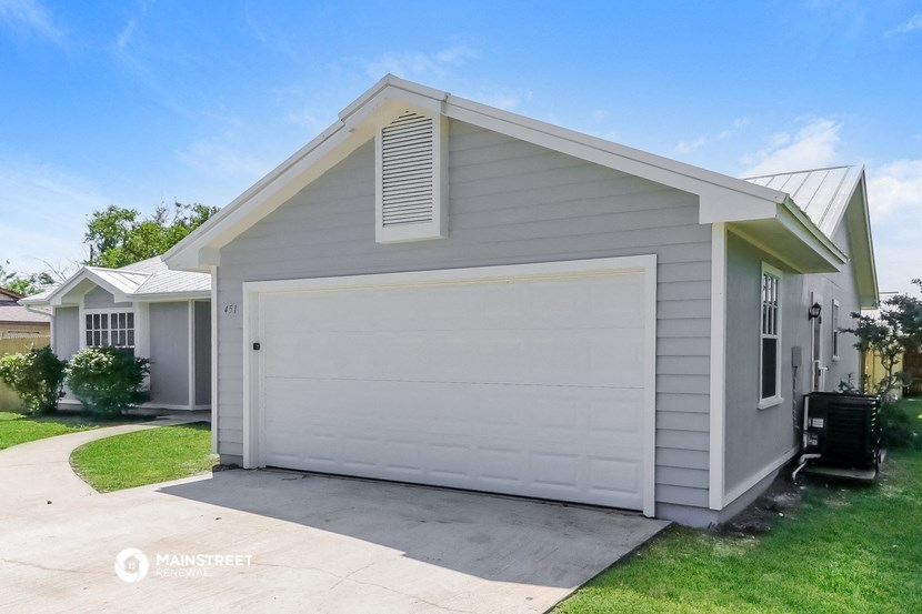 a white garage with a white door on the side of a house