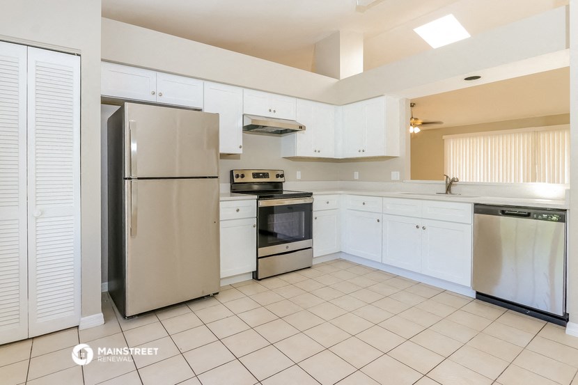 a kitchen with white cabinets and stainless steel appliances