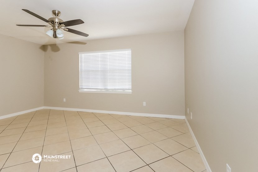 a empty room with a ceiling fan and a tiled floor
